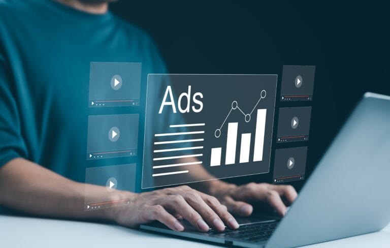 Person at a keyboard, typing with ads and graphs on the screen