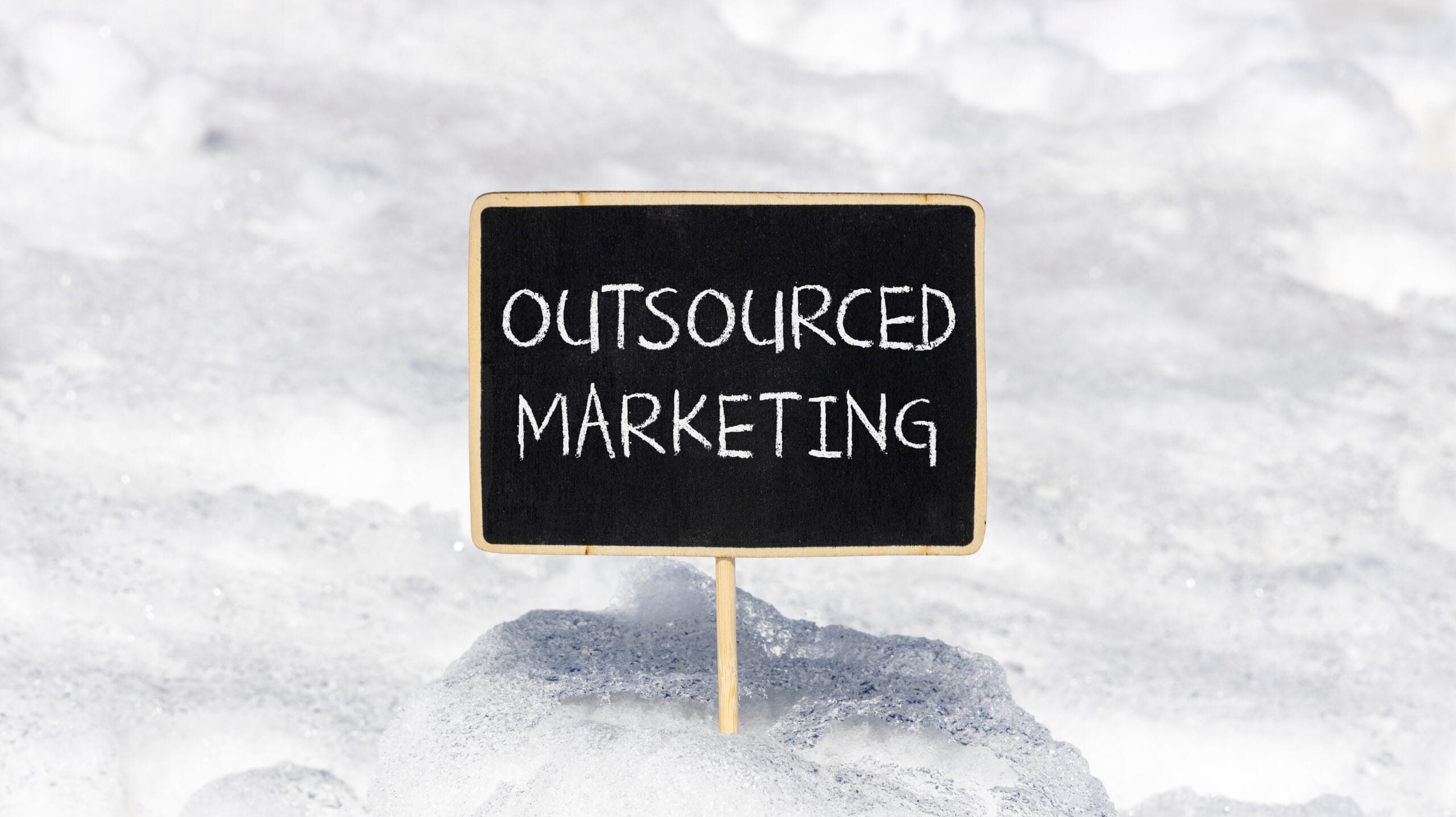 sign in the snow of the words: 'outsourced marketing'