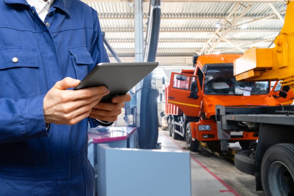 Serviceman,with,digital,tablet,on,the,background,of,the,truck