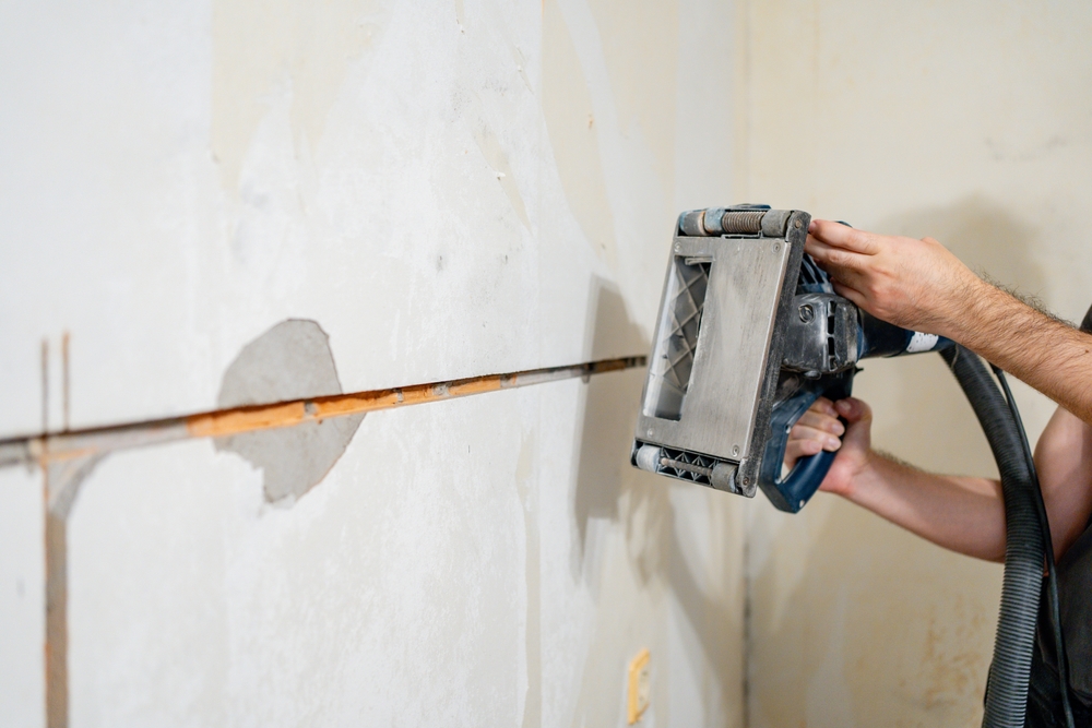 Close up,Of,Man,Operating,Electric,Wall,Chaser,Machine,While,Cutting