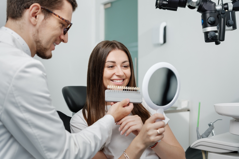 Young,Male,Dentist,In,White,Coat,Show,Veneers,Enamel,Color